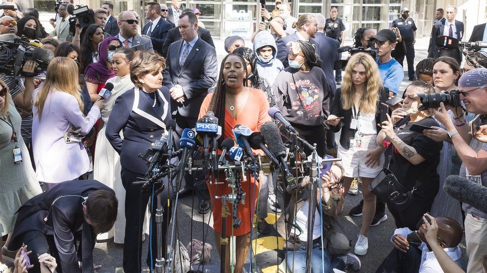 Jovante Cunningham (C), one of the women who have accused R. Kelly of sexual abuse, with attorney Gloria Allred (C-R) at a press conference outside of the United States Courthouse after the former R^B singer was sentenced to 30 years in prison after his conviction last year on federal racketeering and sex trafficking charges in the Brooklyn borough of New York,