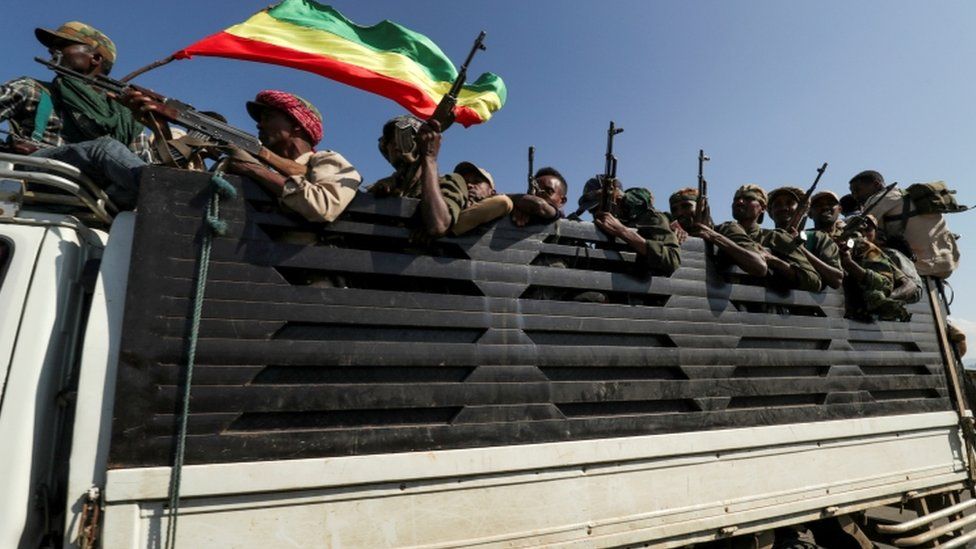 Members of Amhara region militias ride on their truck as they head to face the Tigray People's Liberation Front (TPLF)