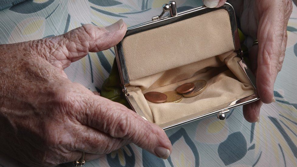 Pensioner holding open purse with coins
