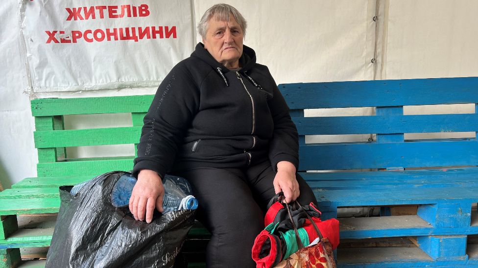 Valentina sits at an aid centre in Odesa with her bags