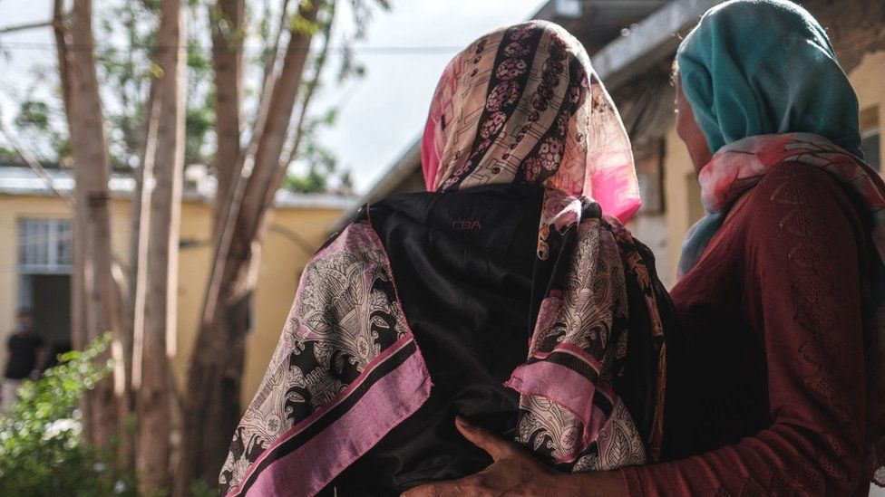 A woman is held by an assistant at a safe house for survivors of sexual assault, in Mekelle in Tigray, Ethiopia - February 2021