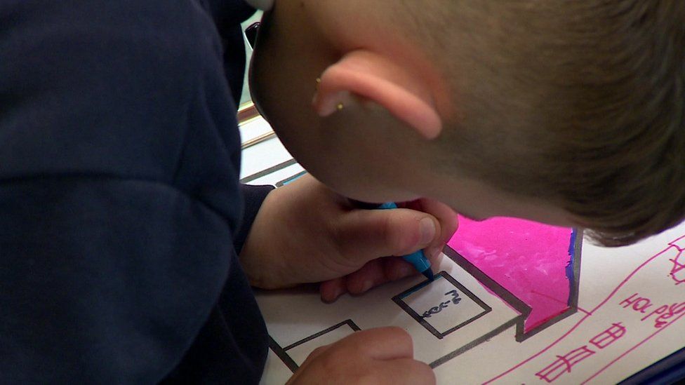 A child drawing a picture of a house