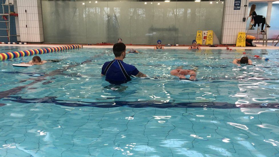 Adults learning to swim as part of a swimming lesson
