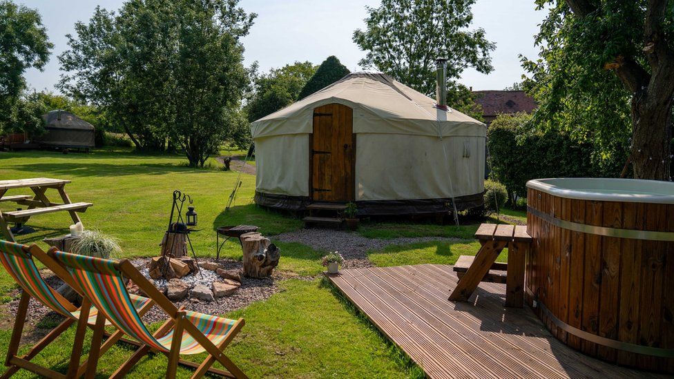 Glamping site showing yurts and people sitting by them