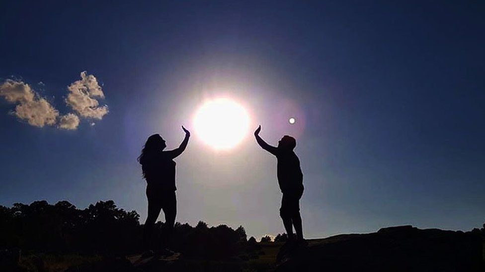 Two people with the Sun