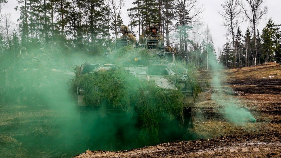A tank coming through green smoke
