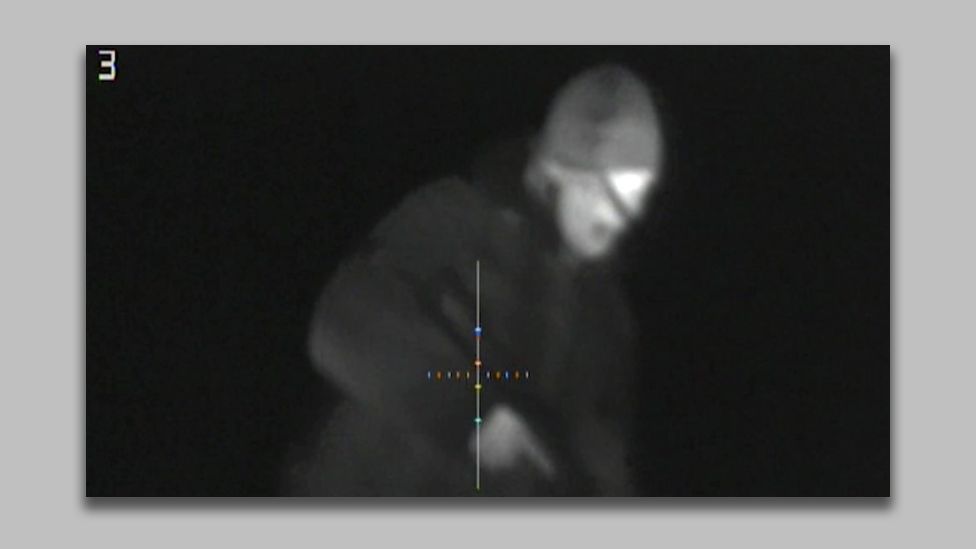 Night vision footage of man holding a gun taken from report alleging a terror attack