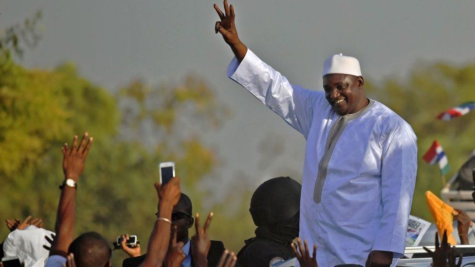 Gambia's President Adama Barrow waves to supporters as he leaves the airport in Banjul on January 26, 2017, after returning from Senegal