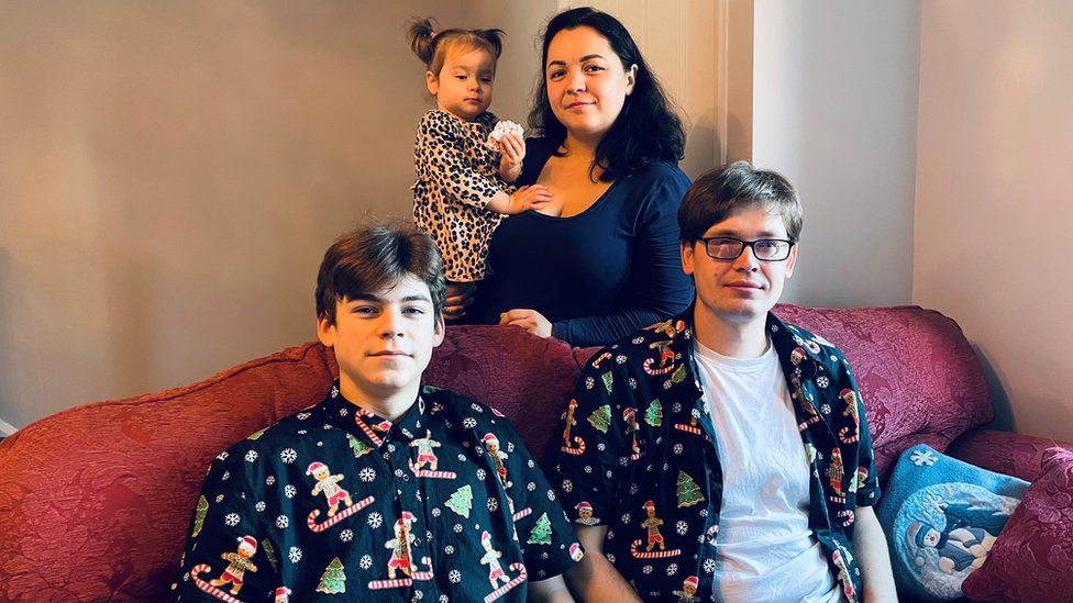 The family pictured together, with Olena holding Nadiya, with Artem and Ivan wearing Christmas shirts