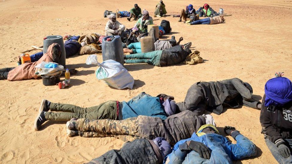 This photo from 2019 shows a group of migrant men resting before carrying on their journey across the Air dessert, northern Niger, towards the Libyan border