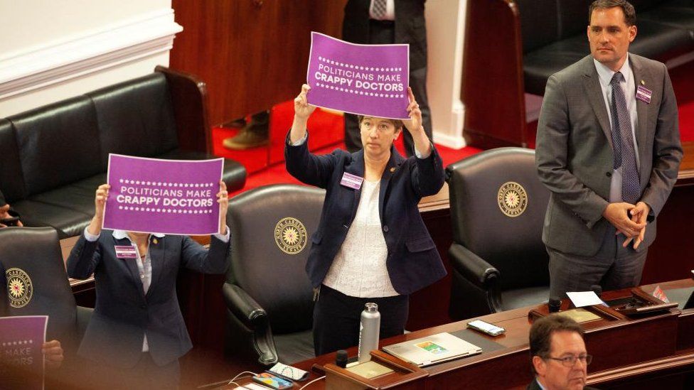 Democratic lawmakers protest after North Carolina Republican lawmakers vote to override Democratic Governor Roy Cooper's veto on 16 May 2023