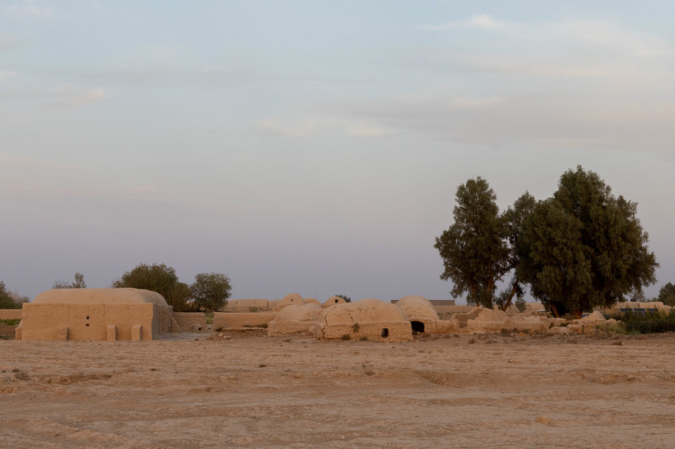 The family lives in a small village made up of traditional mud dwellings, in a village on the banks of the Khash river. Image: Julian Busch/BBC