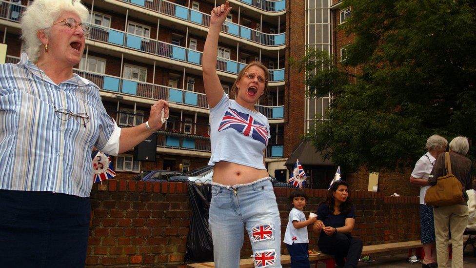 A young woman with a union flag t-shirt and union flags on her jeans celebrates the Queen's 2002 Jubilee in London