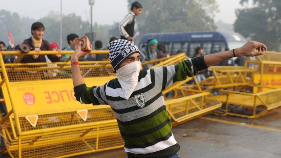 Indian protestor hurling rock during demonstration