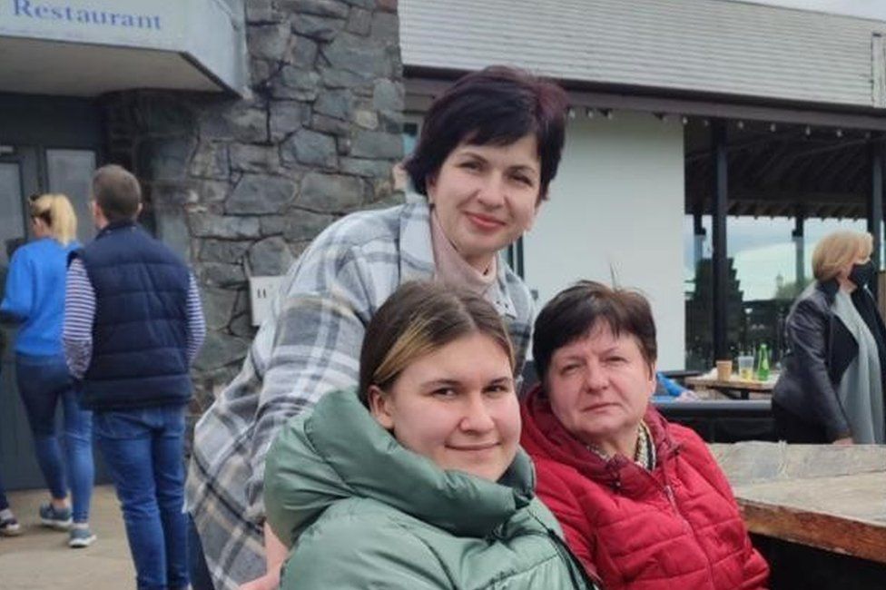 Nadia outside a restaurant with her daughter and sister