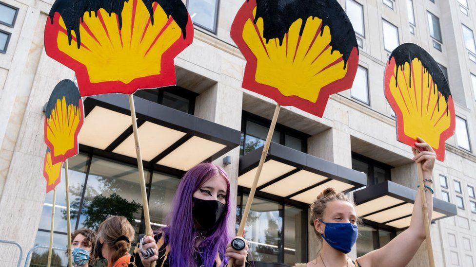 Protesters hold placards with the Shell logo drenched in oil in London, September 2020