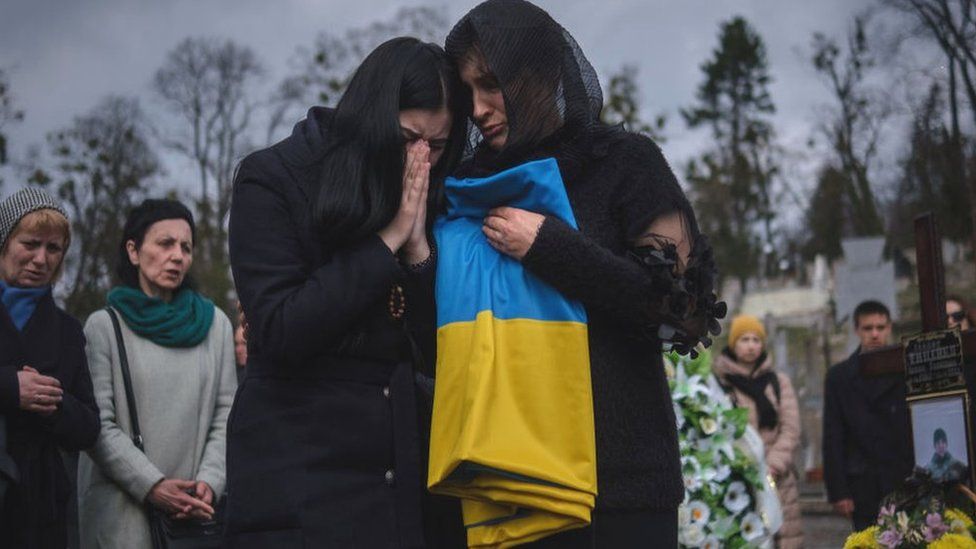 Women crying at a cemetery in Lviv, March 2024