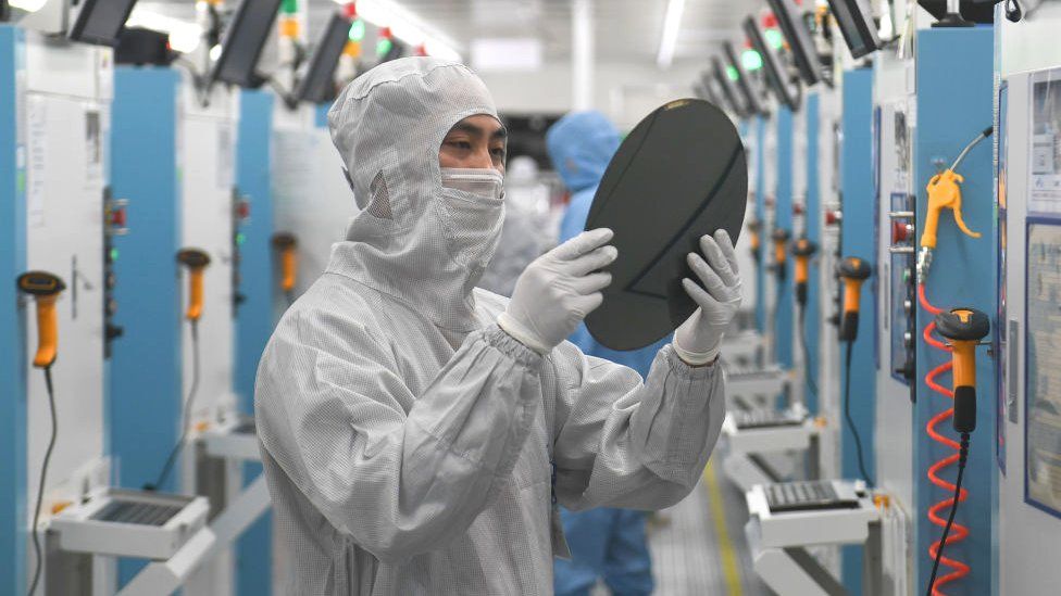 Employees work on the production line of silicon wafer at a factory of GalaxyCore Inc. on May 25, 2021 in Zhejiang, China.