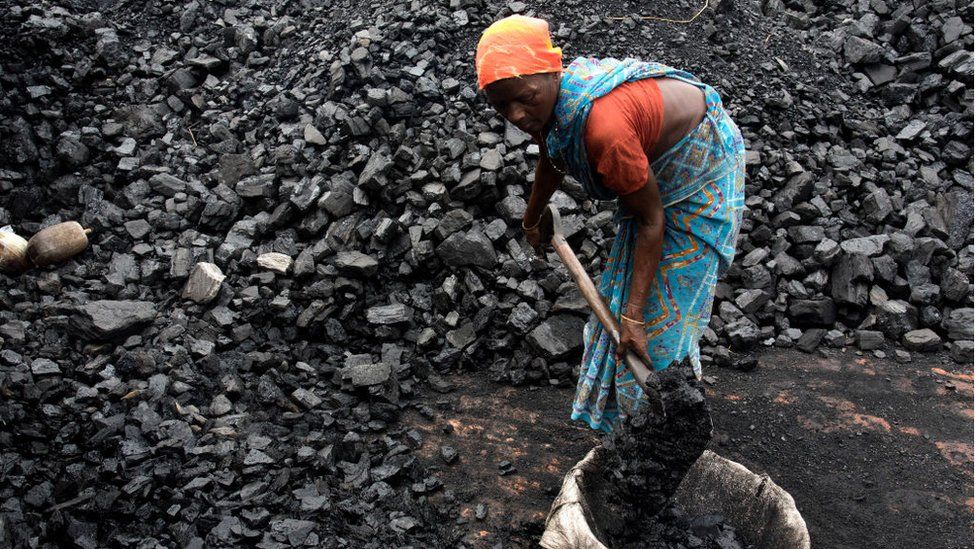 Woman shovels coal in Kamduni brick kiln. Kamduni, West Bengal, India 08.03.17 The brick kilns of Bengal employ a large number of laborers from distant villages of Bihar, Orissa and Uttar Pradesh