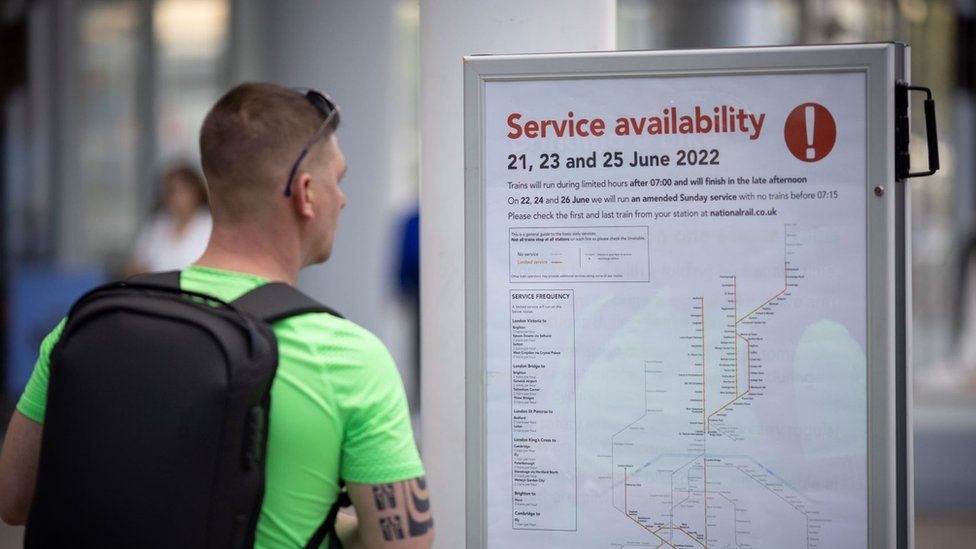 Man looking at notice about service disruption at London Bridge station