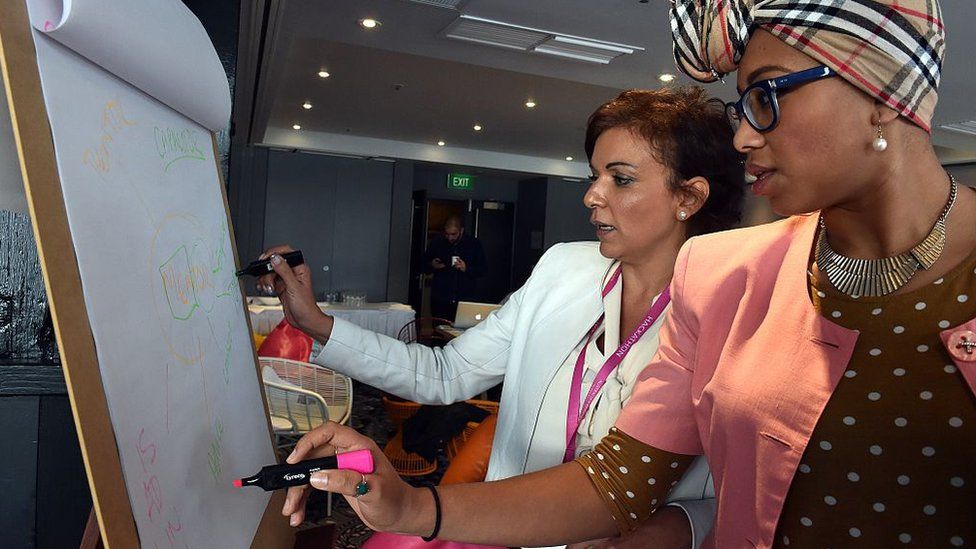 Ms Abdel-Magied stands with a federal MP, Anne Aly, at a summit in 2015