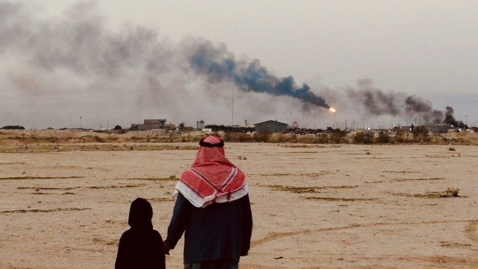 Fatima's father and her sister watch the flares from their home