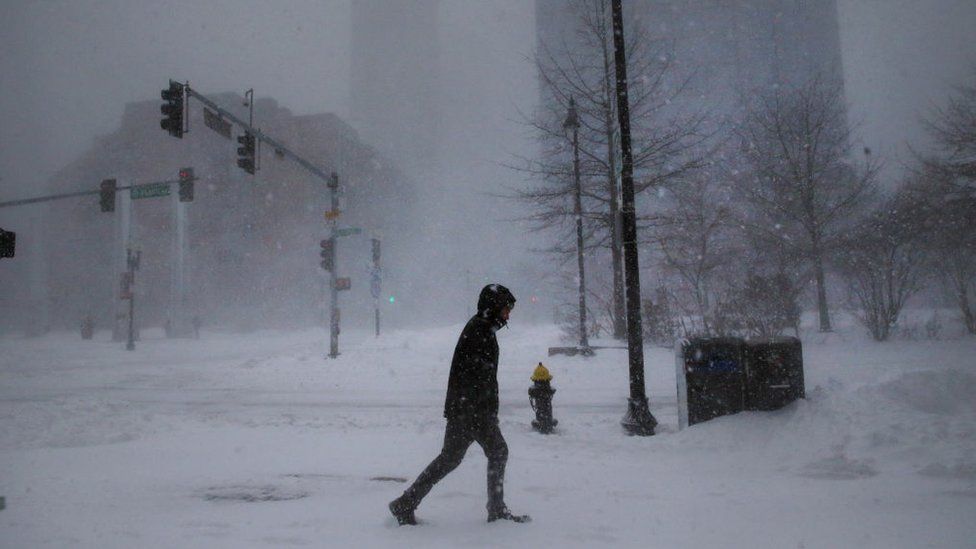 A lone man walks on Atlantic Ave. during the snowstorm in downtown Bosto