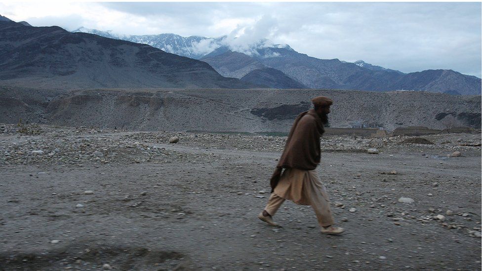 An Afghan man walks through a village in Nuristan Province, Afghanistan, 2009