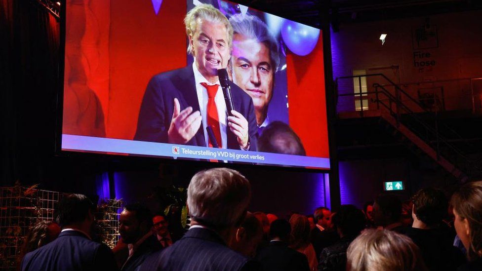 Dutch far-right politician and leader of the PVV party Geert Wilders appears on a screen as supporters of Dilan Yesilgoz, the leader of VVD, gather for exit poll