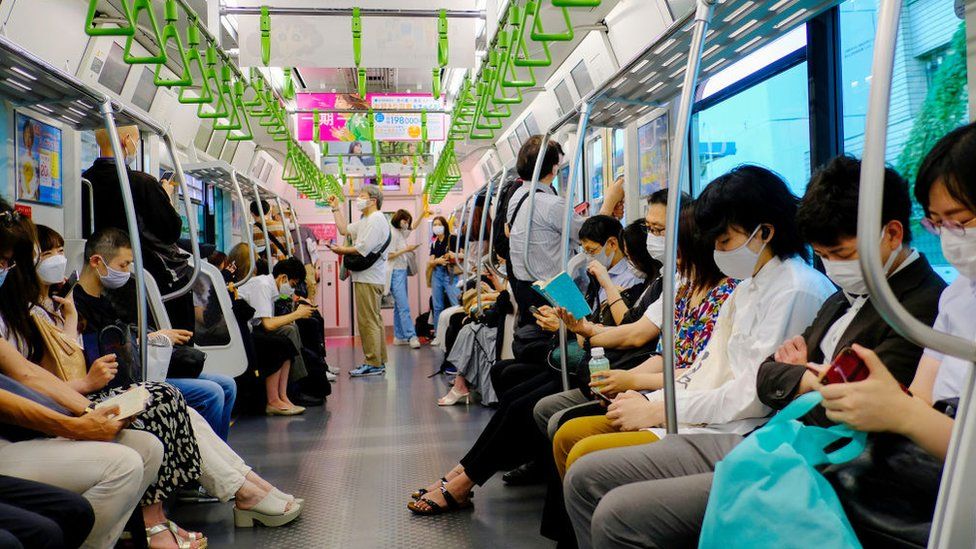Passengers wearing face masks as a preventive measure against the spread of covid-19 are seen inside a Yamanote-line train in Tokyo