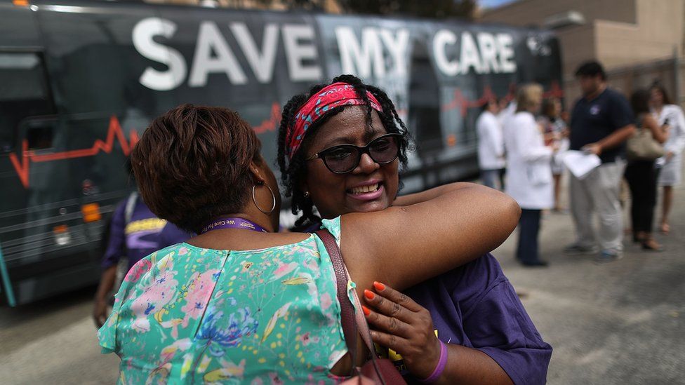 Margalie Williams, a cancer survivor, is hugged after speaking during a rally near Jackson Memorial hospital in Miami, Florida.