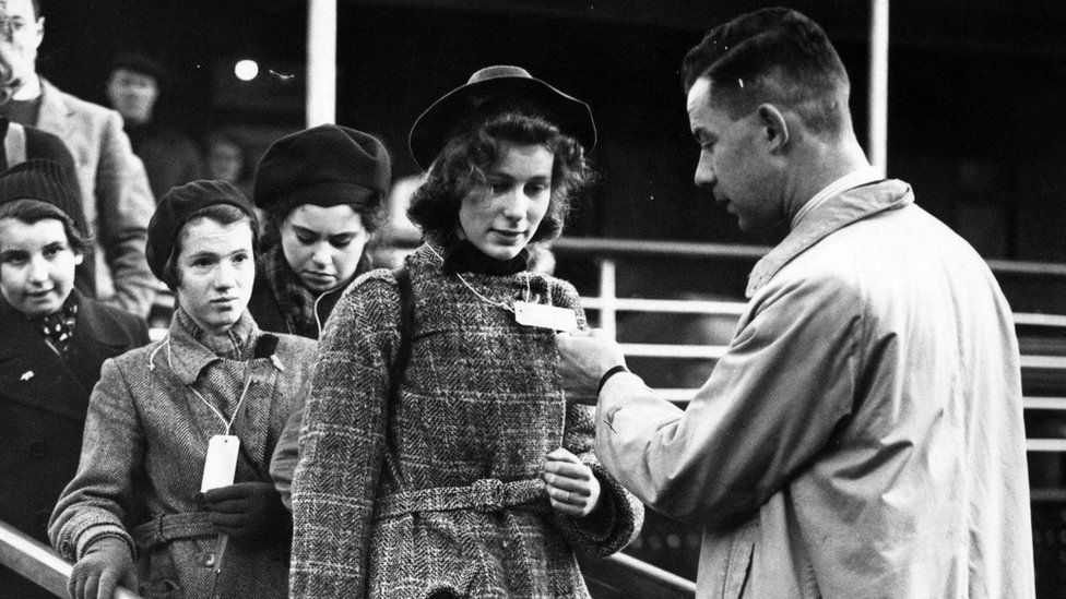 Young woman's identify tag is checked as she leaves a boat at Harwich, Essex, on 2 December 1938