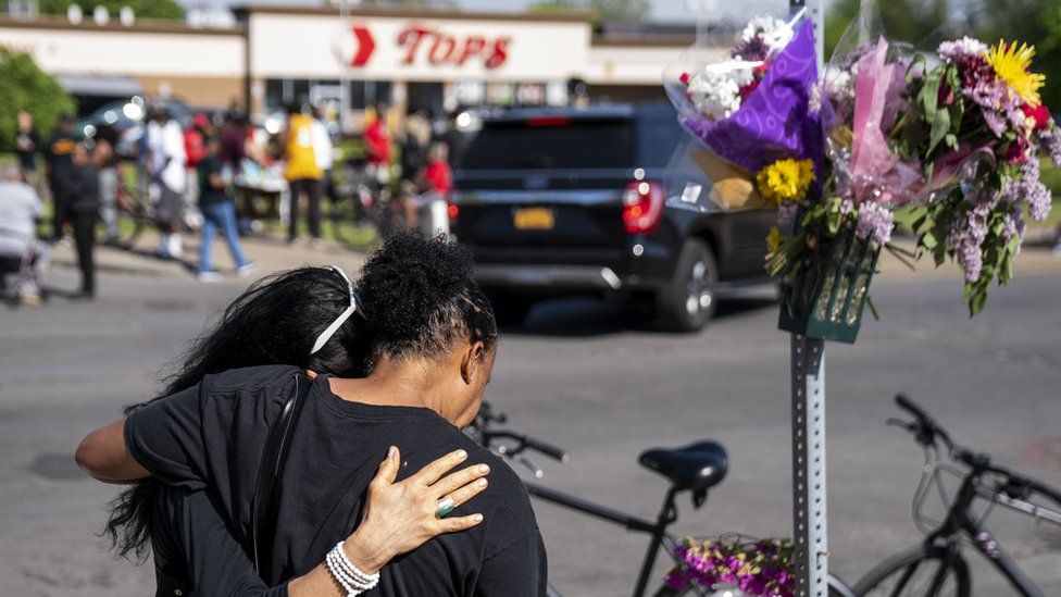 Jeanne LeGall, of Buffalo, hugs Claudia Carballada, of Buffalo, as she gets emotional, as she pays her respects at an makeshift memorial as people gather at the scene of a mass shooting at Tops Friendly Market at Jefferson Avenue and Riley Street on Sunday, May 15, 2022 in Buffalo, NY