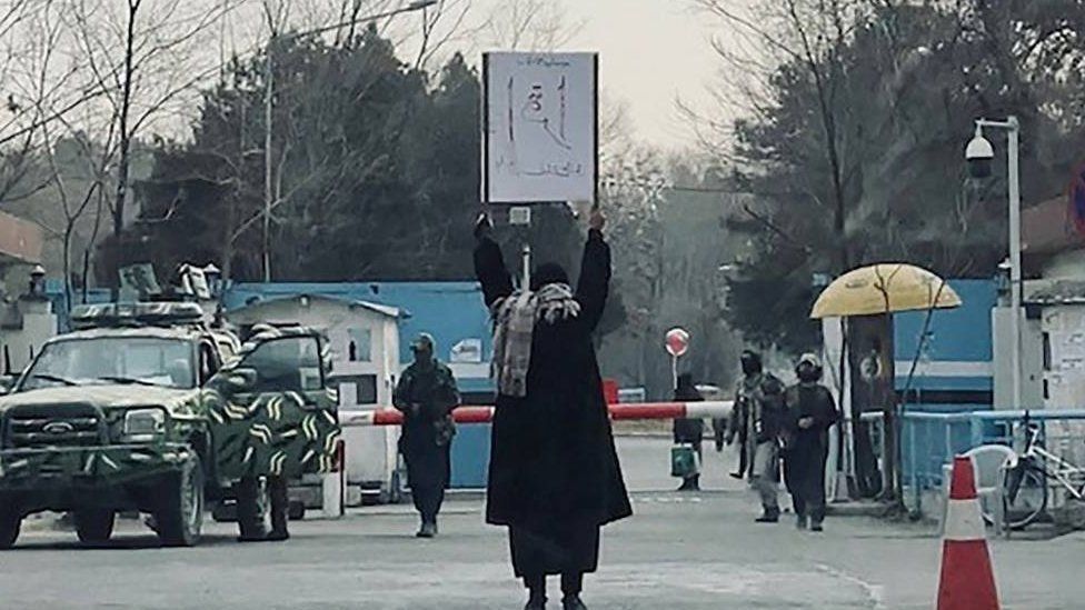 A woman protesting the Taliban's ban on education alone in front of Kabul University. Published on social media and shared with the BBC