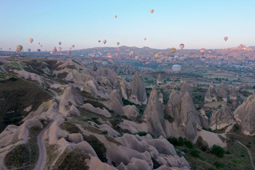 Hot air balloons glide over the historical Cappadocia region, located in Nevsehir province, Tukery on June 15, 2022.