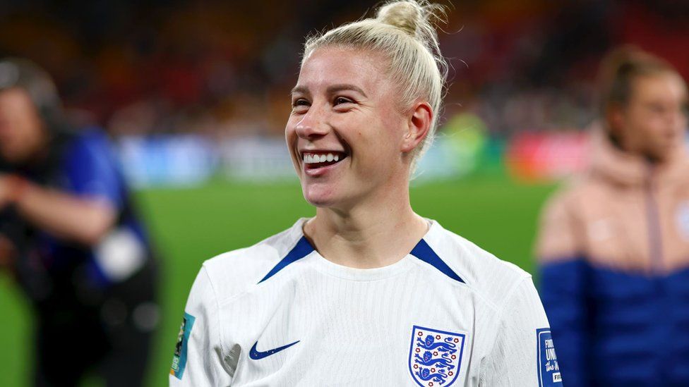 Bethany England of England during the FIFA Women's World Cup Australia & New Zealand 2023 Round of 16 match between England and Nigeria at Brisbane Stadium. Bethany is a 29-year-old white woman with long blonde hair tied in a bun at the top of her head. She wears the white England shirt complete with three lions logo and blue trim. She smiles into the crowd.