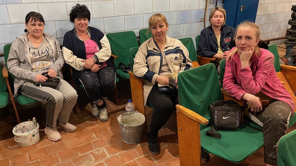 Women who clean and weed and paint at the power plant, sit in a bunker