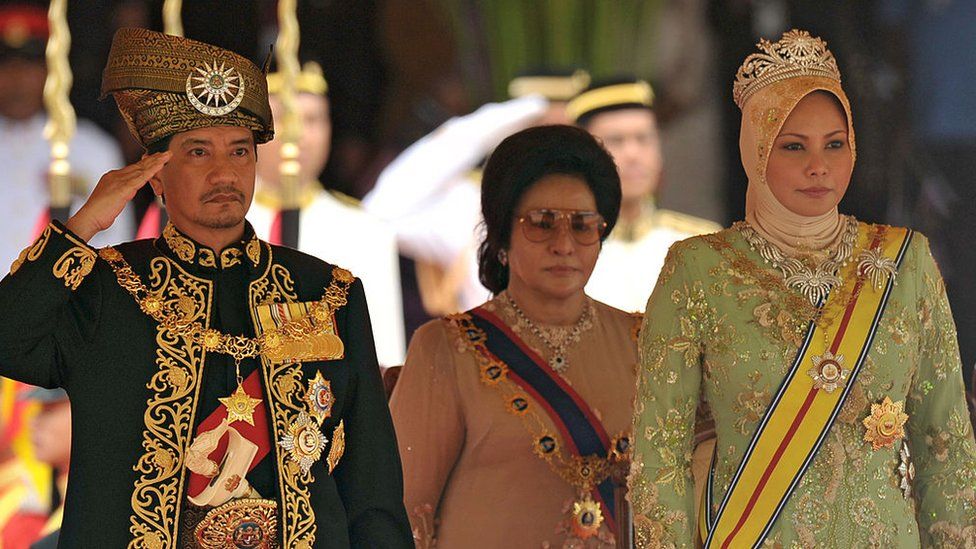 The outgoing 13th king of Malaysia, Tuanku Mizan Zainal Abidin (L) and Queen Nur Zahirah (R), stand for the national anthem during a farewell ceremony in Kuala Lumpur on December 12, 2011. (Photo credit: MOHD RASFAN/AFP via Getty Images)