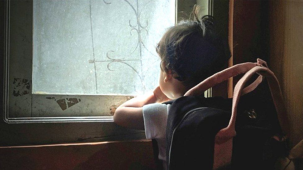 Boy looking through window