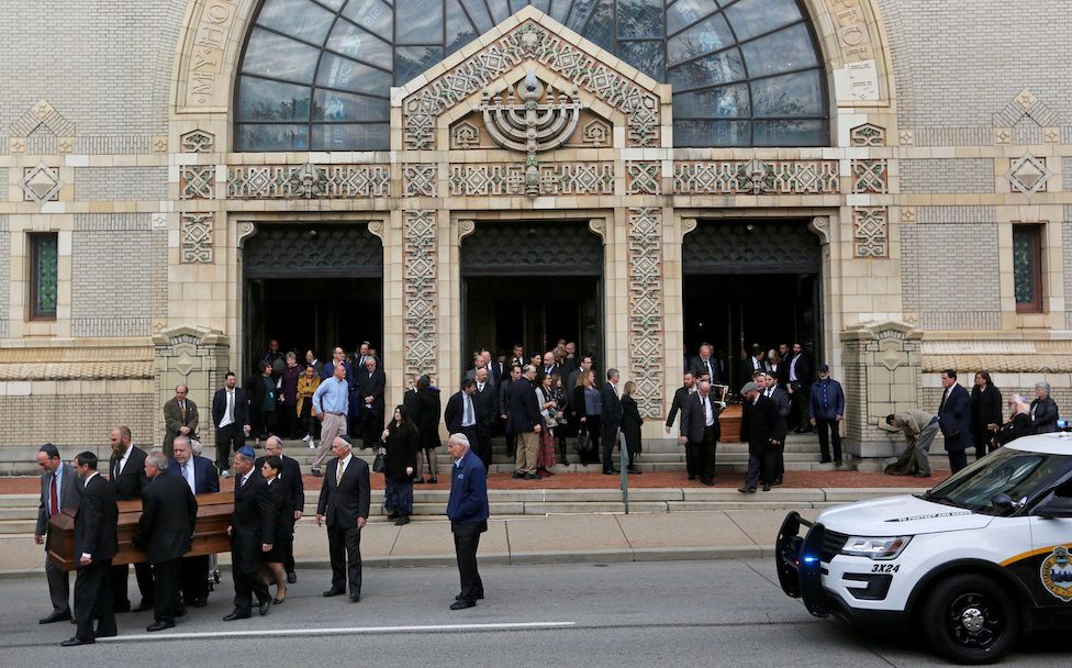 Caskets are carried from Rodef Shalom Temple after funeral services for brothers Cecil and David Rosenthal,