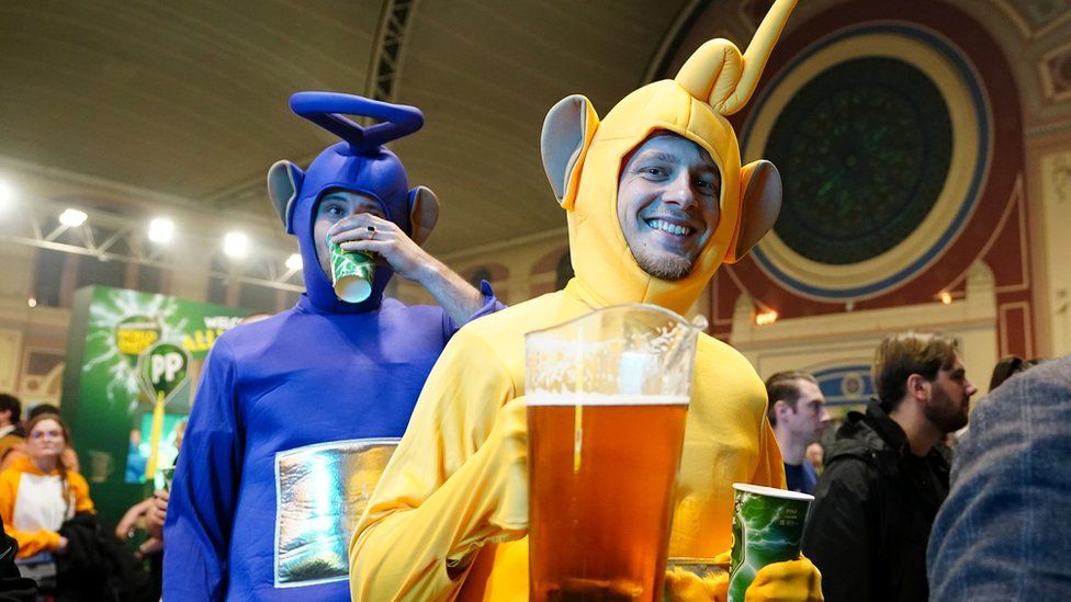 A general view of fans before the final of the Paddy Power World Darts Championship at Alexandra Palace, London, with two men carrying beer and dressed up like the Teletubbies