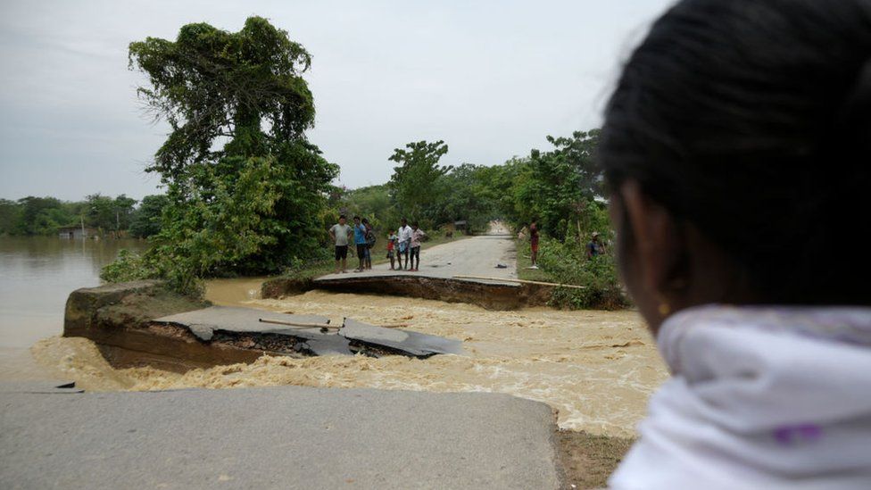Villagers standing near a damaged road after flooding flowing heavy rainfall, in Nagaon, Assam, India on 20 May 2022.