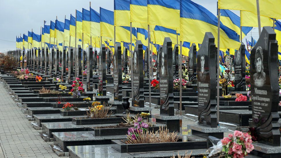 National flags fly above the graves of Ukrainian soldiers in Kharkiv