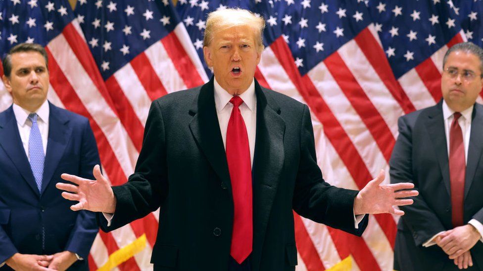 Donald Trump, flanked by his lawyers, holds a press conference after a judge scheduled his criminal hush money trial to begin on 15 April.