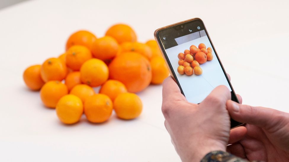 A man taking a photo of food on the Olio app
