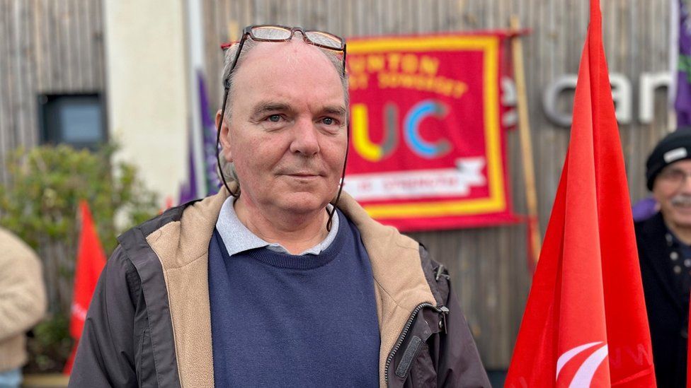 a man surrounded by red protest union flags