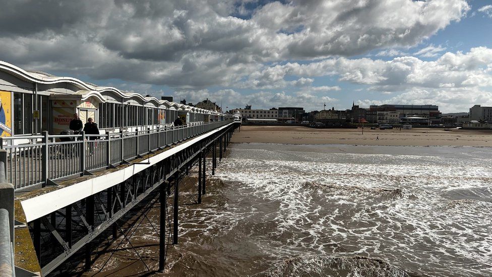 Weston super Mare pier looking towards the town with stormy skies overhead