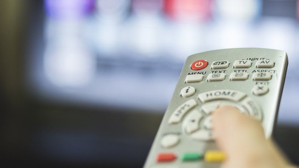 A remote control in front of a television