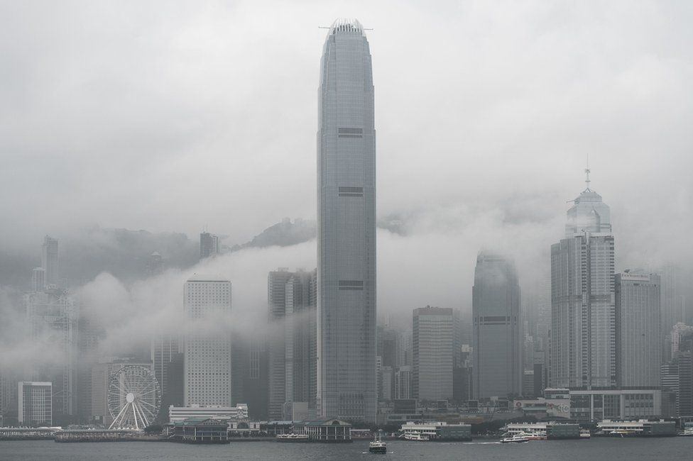 The International Finance Center tower (C) and the city skyline are seen shrouded in fog in Hong Kong on 9 March 2016