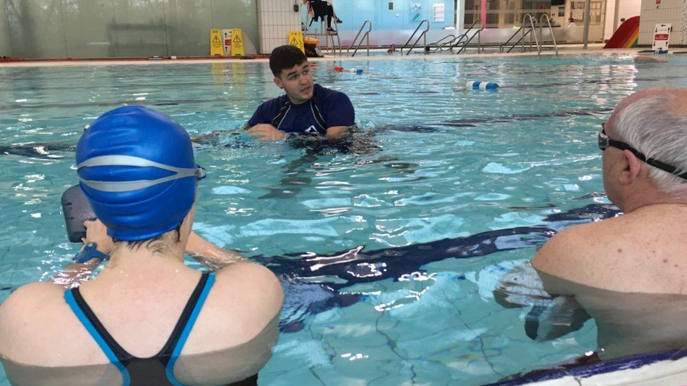 A swimming instructor teaching a class